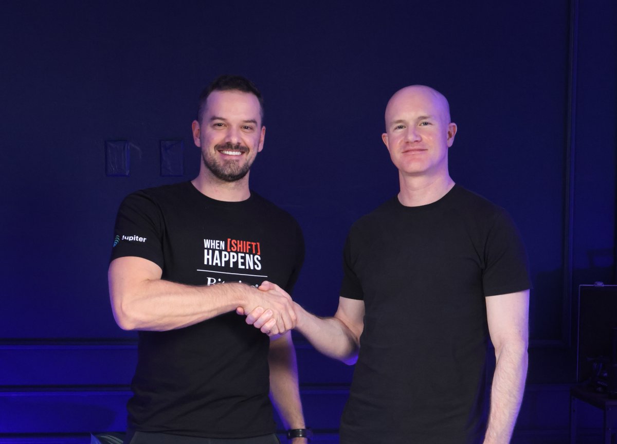 Brian Armstrong shaking hands with podcast host Kevin