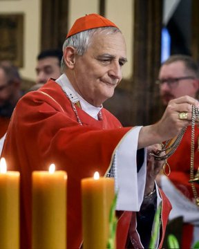 A man wearing red cardinal robes and a red zucchetto stands in a church interior holding a gold rosary chain in his right hand, with several lit yellow candles in the foreground on a surface, and blurred background figures including other clergy. The second image shows the Palestinian flag with black, white, green, and red triangular and rectangular sections.