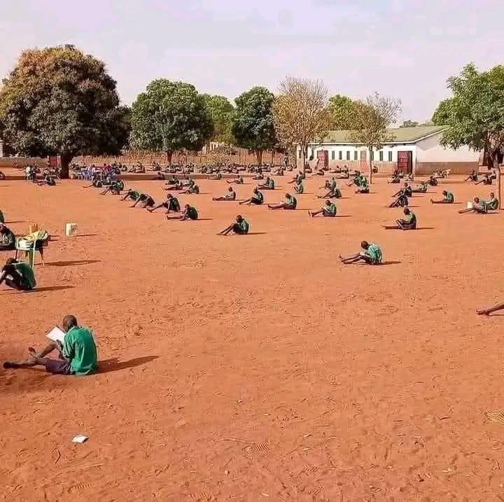 HKitambula's tweet photo. Opportunists are misinforming the public that the photo below is of a school from Buyende district where P.7 pupils sat PLE like this. This is false. The photo is of Holy Cross Comboni Primary School Yirol, South Sudan not Uganda. #SayNoToMisinformation https://t.co/i17R6nwLRK