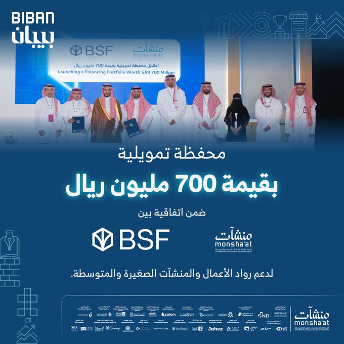 Group of men and women in white traditional Saudi attire and headscarves stand on a stage during a formal signing event with a large screen displaying BSF and Monshaat logos in the background. Arabic text overlay announces the 700 million SAR financing portfolio launch by Monshaat and BSF for supporting SMEs and entrepreneurs. Logos of BSF and Monshaat appear at the bottom with additional Arabic text describing the partnership.