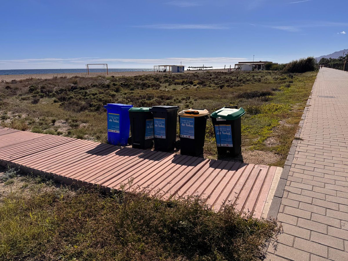 Nos alegramos de que se mantengan los cubos de basura de reciclaje en la playa...
Aunque quizá es hora de buscar una solución más estética que también evite que reposen sobre la arena.
Crear un cubículo de madera que los reúna a todos es quizá una solución.