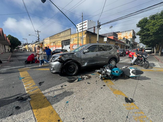 First image displays police officers in black uniforms and red jacket, and emergency medical personnel in white uniforms with red cross from Cruz Roja Guatemala assisting an injured person on a stretcher into the open back of a white ambulance van marked with POLICIA and Cruz Roja on the side, on a city street with buildings and traffic lights in the background. Second image shows a damaged gray SUV with front-end collision on a street lined with graffiti-covered walls, trees, and buildings under a partly cloudy sky, with a fallen turquoise motorcycle nearby, scattered debris including a blue helmet, and bystanders in casual clothing observing the scene.