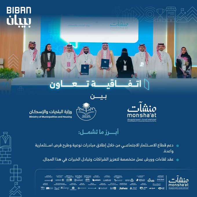Group of men and women in traditional Saudi attire including thobes and abayas standing on a stage holding certificates or awards with smiles. Large backdrop displays Biban logo in Arabic and English along with event details. Front signage shows Ministry of Municipalities and Housing and Monshaat logos. Palm tree emblem and Jada logo visible at bottom. Arabic text overlay describes the cooperation agreement for social investment support.