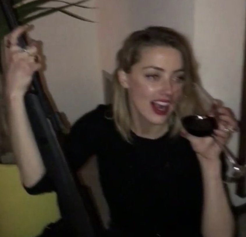 AmberStansTakes's tweet image. Johnny Depp drunk in a video fleeing from Amber Heard is proof that he is an abuser, but not Amber Heard holding a gun with a wine glass in her other hand