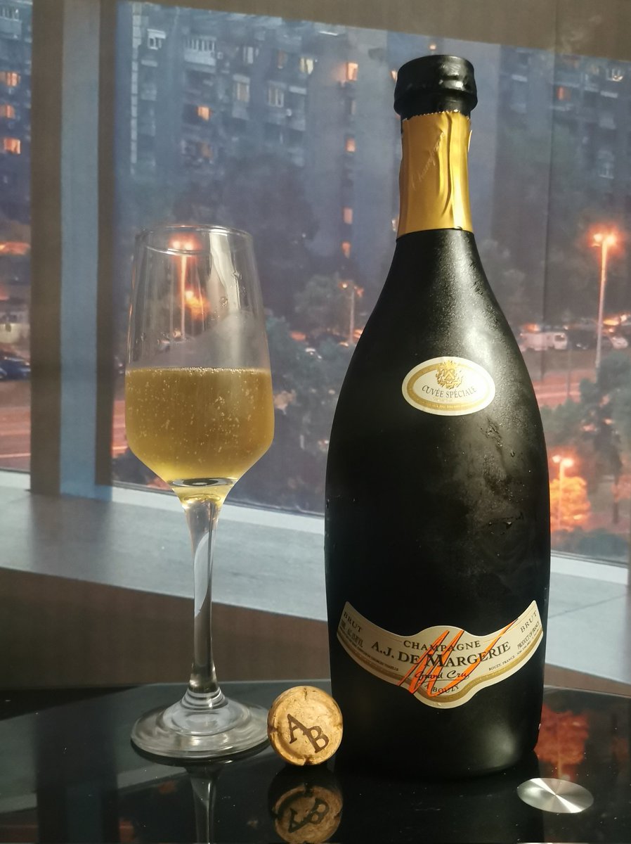 A.J. De Margerie Grand Cru Brut (NV) is a pale-gold, clear Champagne with medium intensity and a fine, persistent mousse; the clean, medium(+) nose reveals youthful primary red-berry (cherry, strawberry), citrus (lemon, lime) and stone-fruit (peach, pear) aromas layered with
