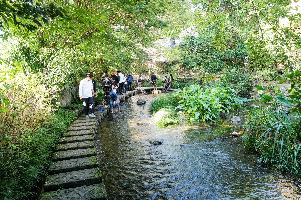 ryo14da's tweet photo. 東京近郊のまちづくりに悩む人は三島へ。
地方の建設事業者は加和太建設に学ぶべき。

静岡県三島に訪問。
三島は東京近距離型のまちづくりの成功モデル、加和太建設は地方建設業の星だった。

① 宿場まち三島 - 旦那衆が育んだ挑戦を応援する土壌

三島は東海道や甲州道が交わる交通の要衝。
箱根の難所を越えた最初の宿場町として発展した。現在人口11万人。品川駅37分という好立地と地政的な特徴で魅力的なまちとなっている。

1889年の東海道線開通による宿場町の衰退を乗り越え、軍基地の誘致、新幹線三島駅の誘致、石油コンビナート建設の反対など30年ごとに大きな節目を乗り越えてきた。

これらの変化を支えたのがまちの旦那衆。
資金を背景にロビー活動を実施し、挑戦を応援する土壌を生み出した。

② 地方建設業の星 加和太建設

現代の旦那衆の筆頭が加和太建設。
3代目の河田亮一社長が経営を引き継ぎ、16年間で売り上げを30億円から180億円に。土木・建築事業に加えて三島の不動産開発、ConTech事業を展開。建設DXコミュニティをつくり日本全国の地方建設事業者110社をつないでいる。

建設需要がシュリンクする中で地域とつながり、自ら開発をして需要創出をしていきながらそのノウハウをサービスと共に横展開していくあり方は地方の建設事業者の星だ。

③せせらぎと三島デルタの連続開発

三島のまちの特徴にせせらぎがある。
1万年前の富士山噴火の溶岩はちょうど三島で止まった。
上流からの伏流水が三島で湧き出し、まちじゅうに用水路が張りめぐらされた。

これが三島の重要な修景となっている。特に公園・三嶋大社・川・旧東海道で囲まれた駅前の三角地帯は魅力的な店舗が多い。

この「三島デルタ」で旦那衆である加和太建設とまちづくりNPOのみしまびとが連携することで、連続的にボトムアップな施設・事業が生まれている。どの施設もデザインとアイディアのクオリティーがとても高く、三島の底力を感じる。

④ あひる図書館 - 持ち寄り図書がつくるリアルなSNS

あひる図書館は、居酒屋の2階にある施設図書室だ。
一箱月2,000円でオーナーになって自分の本を貸し出せる。
本棚にはオーナーの個性が出てリアルなインスタのウォールのよう。現在オーナーは75人。オーナー間のコミュニティーもあり、借りた人からコメントも寄せられる。
全ての本がシステム管理されてサイトで蔵書も見れ、デジタルとリアルの塩梅が絶妙だ。

⑤ ゲストハウスgiwa - 旅行者と地元民をかき混ぜるガチャと1時間限定のバー

寿司屋をリノベーションしたゲストハウスgiwa。
周囲の飲食店の割引券が出る晩御飯ガチャと21-22時だけオープンするバーの仕組みが面白い。
ガチャで出るローカルな店で楽しんだ後、みんな飲みに戻ってくる。地元の人も集う。1時間では物足りずそのままどこかに行くから宿泊者と地元の人が連れ立っていきやすい。

⑥ まちでみんなでつくる蒸留所 Whiskey & Co

まちのど真ん中にあるウィスキーとジンの蒸留所 Whiskey & Co。
ジャパニーズウィスキーは小麦を使ったスコッチスタイルが主流だが、ここはトウモロコシを使ったバーボンスタイル。

あえてまちなかでつくってみんなが訪れやすくし、樽を地域のパートナーに分散して熟成。さらに熟成する時間を逆手にとってトークンでみんながオーナーになれる。並行してつくっているジンも絶品。

⑦ 圧巻のSANAA建築と経営力の加和太建設

視察の〆は加和太建設オフィス。
金沢21世紀美術館を手がけたSANAAによる設計。屋上の雲のようなコンクリート打ちっぱなしのテーブルでは自然に人が集い、奥には富士山が見える。
社内の賞金付き作文コンテストをまとめた冊子やZINEなど経営力がそこかしこに見える。
これはあらゆる地方建設事業者が参考にすべき。

<まとめ>
施設・地域・企業  - 多くの主体が参考にすべき場所

富士山の噴火でできた伏流水とせせらぎと、宿場町の旦那衆が築き上げた挑戦を応援する文化、30年ごとに地域を再定義し直すレジリエンス。

これらの土壌に加和太建設をはじめとするプレイヤーの新しい挑戦が魅力を重ね続けている三島。
東京から近距離の地域が個性を確立するのに苦しむ中、一つの成功モデルと言える。

一つ一つの取り組みも他の地域への展開性が高いものが多くそれぞれデザインやアイディアのレベルがとても高い。ここで紹介した取り組み以外にも参考にすべき場所が多かった。

施設・地域・企業、どのレイヤーでも参考にすべき部分がたくさんあり多くの人が訪れる場所だ。

同行させていただいた薩摩大学の皆様、ありがとうございました！