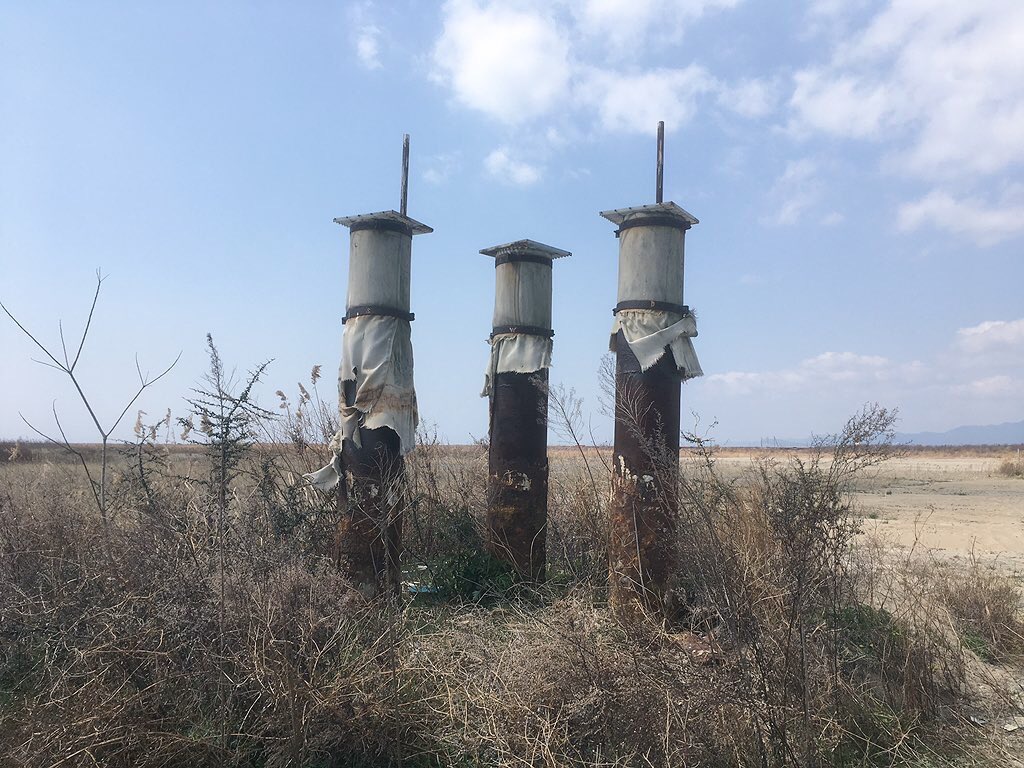 写真発掘。2017年の夢洲（万博会場）を歩いたときの。潮風だけが吹く、無味無臭の地。
2枚目は排水溝？グレーチングが置いてあった。この高さまで土地を嵩増ししなきゃいけなかったのかな…？