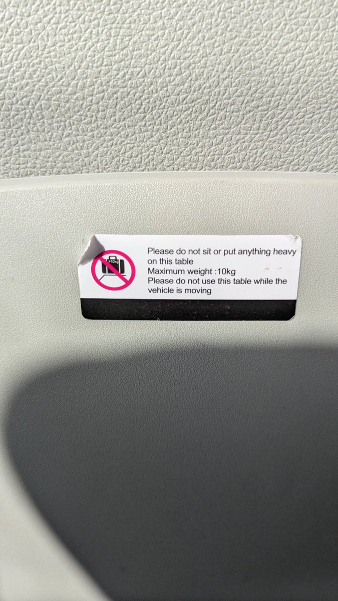 I'm on a <a href="/FlixBus/">Flix</a> and I've noticed this sign in front of me. What am I supposed to be using this table for if I can't use it while it's moving? 

P.S - please get rid of the seat allocations, nobody takes any notice of it