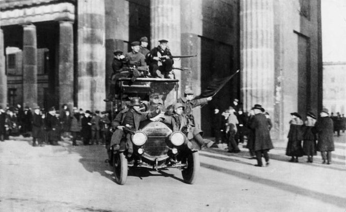9 November 1918: revolutionary soldiers wave a red flag in front of the Brandenburg Gate in Berlin (via Bundesarchiv)