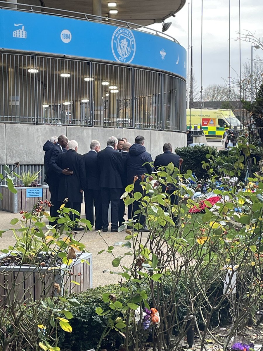 OllieHolt22's tweet photo. Some of my all-time heroes paying their respects to the fallen in a lovely, quiet ceremony outside the Etihad. Alex Williams with an arm around Mike Summerbee, and Peter Barnes next to Summerbee, and Paul Lake and Gary Owen there, too https://t.co/bOcvU0sOQ4