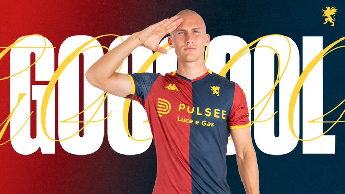 Leo Østigaard stands in a red and blue Genoa CFC jersey with sponsor logos including Pulse e Luce Gas, raising his right hand in a salute gesture, with golden text GOOOOL overlaid and the team griffin emblem visible.