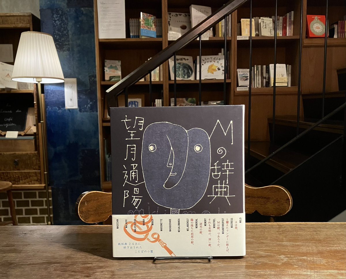 kurumidoshoten's tweet photo. 深い紺色の地に描かれる、丸い瞳の独特のお顔。望月通陽さんの『Mの辞典』（ゆめある舎）は、元々1990年代につくられた原画を、時を超えて作品集にしたもの。望月さんの版画と詩で構成された魅力あふれる一冊です。（な https://t.co/vInvGfwu4Q