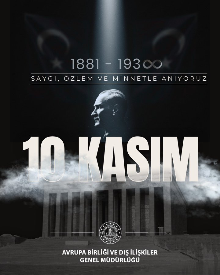 A dark background with a beam of light shining from the top center. In the center a large white text reads 10 KASIMIMIZ with clouds below it. Above the clouds a silhouette of a mans profile facing left with hair combed back. To the right of the silhouette white text reads 1881-193∞. Below that larger text reads SAYGI ÖZLEM VE MİNNETLE ANIYORUZ. At the bottom a gray image of a building resembling a mausoleum with a seal-like emblem on it. Below the building white text reads AVRUPA BİRLİĞİ VE DIŞ İLİŞKİLER GENEL MÜDÜRLÜĞÜ.