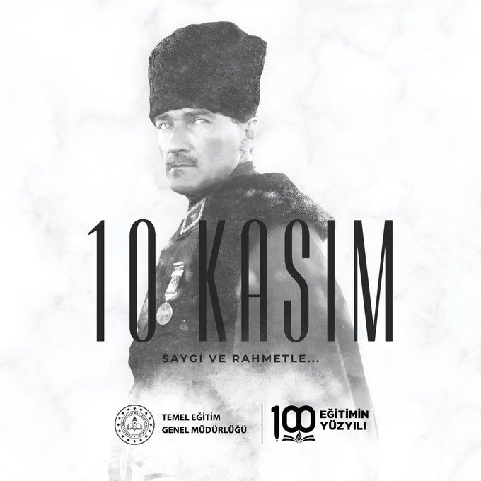 A black-and-white portrait of Mustafa Kemal Atatürk standing in formal military attire including a long coat, medals on his chest, and a fur hat, positioned against a plain background. Overlaid bold white text reads 10 KASIM SAYGI VE RAHMETLE at the top and bottom. Logos of Temel Eğitim Genel Müdürlüğü and 100 Yılı appear at the bottom corners.