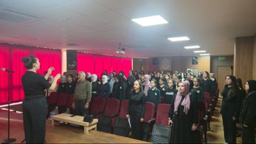 First image shows a graphic with Turkish text overlay on a background of a historical mausoleum building and a superimposed portrait of a man in a suit looking thoughtfully with a red rose emblem and school emblems at the bottom. Second image depicts a woman in dark clothing speaking into a microphone in front of an audience of women and girls in headscarves and uniforms seated in a conference room with red curtains and a projector screen. Third image captures a group of adults and young children in casual and traditional clothing gathered around a potted sapling tree in an outdoor urban area with apartment buildings and trees in the background planting the tree. Fourth image illustrates children and adults in school uniforms and casual attire kneeling in a circle around a newly planted small green sapling in soil outdoors near a fence with urban buildings visible engaging in the planting activity.