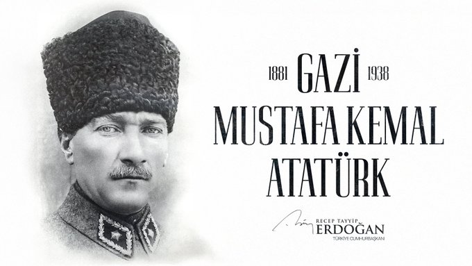 Black-and-white portrait of Mustafa Kemal Atatürk wearing a military uniform and feathered hat, standing formally with a mustache and serious expression, overlaid with the text 1881 GAZİ 1938 in large font above his head and MUSTAFA KEMAL ATATÜRK below, plus a signature reading Recep Tayyip Erdoğan at the bottom right.