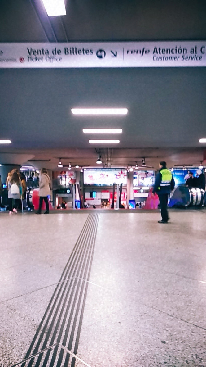El guardián del vestíbulo subterráneo

Bajo el cielo  de la ciudad, donde el hormigón parece respirar y las luces blancas de la estación imitan la claridad artificial de un amanecer sin sol, el vestíbulo se estira como un animal que acaba de despertar. Las escaleras mecánicas