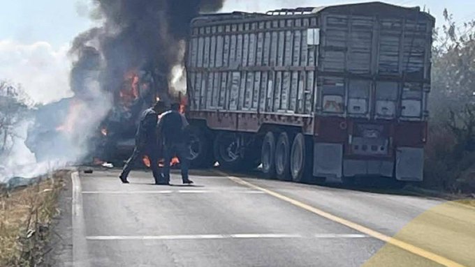 First image displays a large truck trailer engulfed in flames on a rural roadside with thick black smoke rising surrounded by dry grass and a clear sky two individuals in dark clothing walk near the vehicle debris scattered on the ground second image shows a man in a black cowboy hat and colorful patterned shirt smiling in a stadium setting next to a hooded figure in gray hoodie with face obscured by balaclava and another person in tactical gear with blurred faces under bright lights and crowd in background