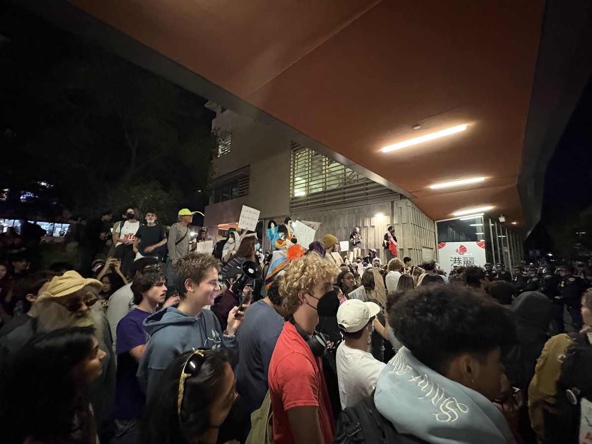 chrissaolson's tweet photo. Big crowd outside the TPUSA event at UC Berkeley right now. Protestors are chanting as cops are lined up with batons. https://t.co/YBQQcjqe7J