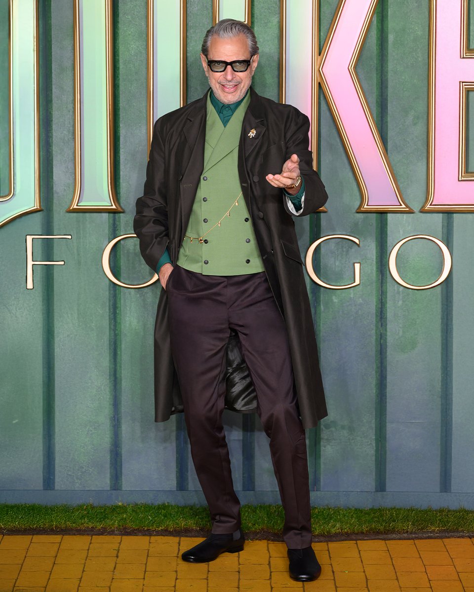 Prada's tweet photo. Cynthia Erivo and Jeff Goldblum wore #Prada while attending the “Wicked: For Good” premiere on November 10, 2025, in London.

#CynthiaErivo wore a Prada blue satin tech dress with a full skirt embellished by laminated vinyl inlays, paired with a black leather belt that accentuates the waist and a black laminated vinyl cape. Satin and brushed leather shoes.

#JeffGoldblum wore a Prada brown moleskin double coat, green mohair vest, bottle green poplin shirt, and brown chino trousers. Black brushed leather shoes.

#PradaPeople