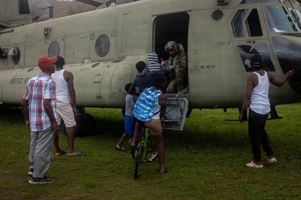 U.S. Soldiers and Marines assigned to Joint Task Force-Bravo (JTF-B), alongside members of the Jamaican Defence Force and firefighters with the Los Angeles County Fire Department’s Urban Search and Rescue Team (USA-02), unload and distribute food and water from a CH-47E “Chinook”