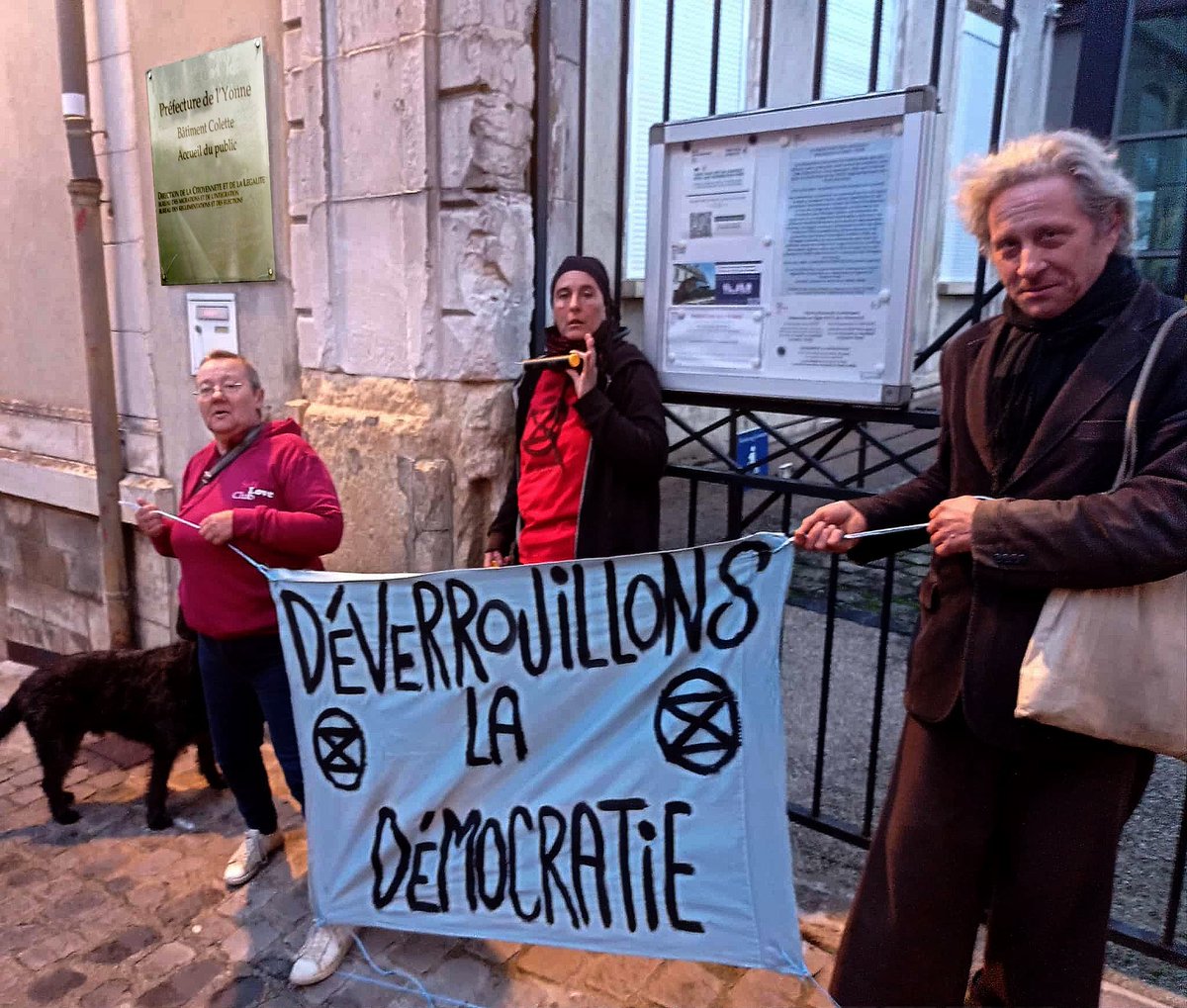 #Auxerre, 10 novembre 2025 — Une militante d’Extinction Rebellion Auxerre s’est symboliquement attachée aux grilles de la préfecture de l’Yonne pour dénoncer l’inaction du gouvernement face à l’urgence écologique et sociale.