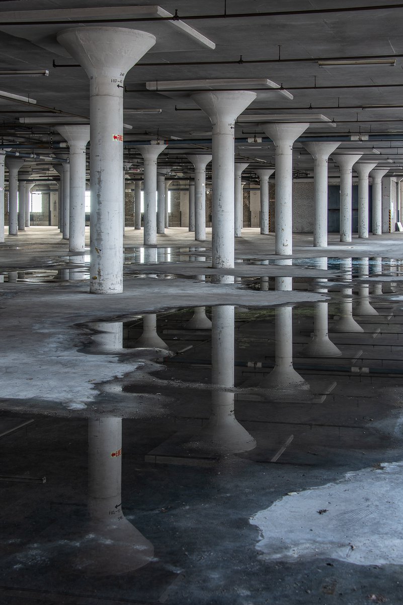 Reflections in recent rainwater on the top floor of a massive storage warehouse in Philadelphia, Pennsylvania.
