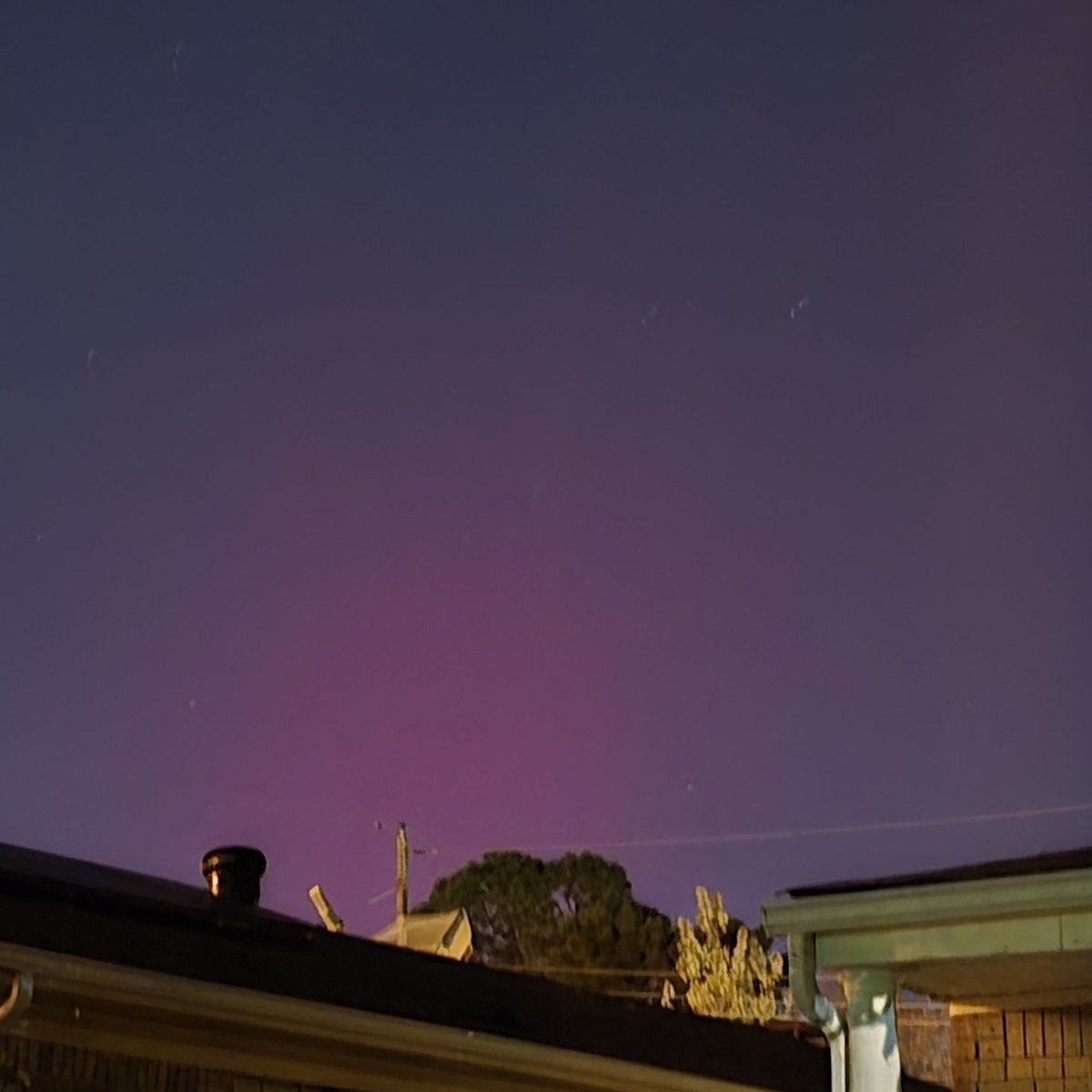 I can confirm the Northern Lights can be seen in Little Rock right now. It comes it waves spend 10 mins or so outside looking north, especially in the country. I took this pic from my home and could see a faint pink glow.