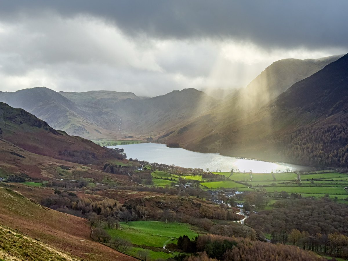 workingtonboy's tweet photo. A shaft of sunlight breaks through an otherwise dark, overcast sky and lights up the lake at Buttermere, Lake District. 
#LakeDistrict #landscapephotography https://t.co/uMWY18yBYp