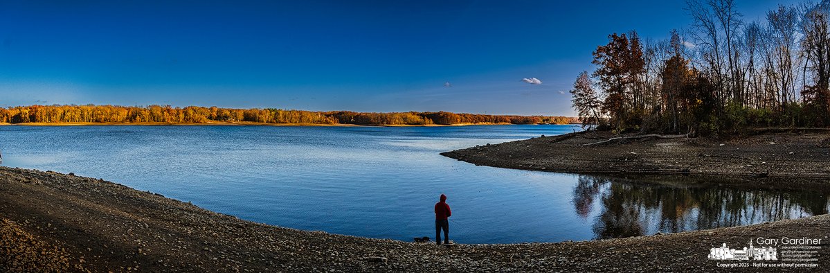 A lone angler casts his line into Hoover Reservoir as the late afternoon sun ignites the autumn foliage across the unseasonably low water, revealing a rocky shoreline that stretches far beyond its usual boundary and offers rare access to normally submerged fishing spots. My Final