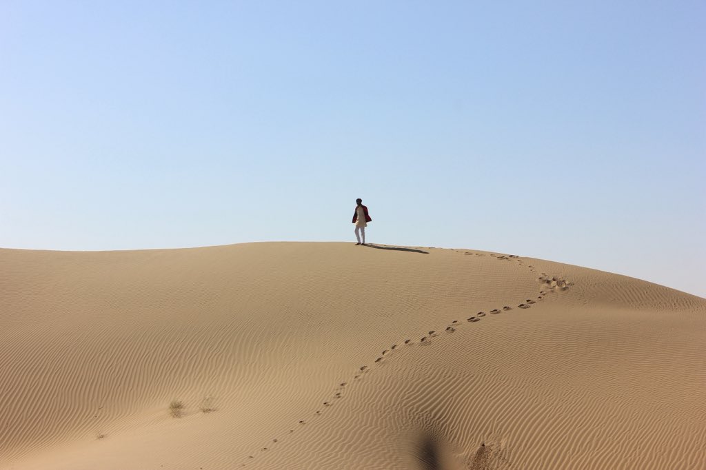 My local driver poses atop a sand dune. 
Shot on: Canon  
Photography: Manish Gupta