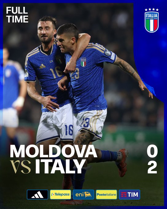 Graphic displays full time score Moldova 0 vs Italy 2 with Italian flag emblem and sponsor logos at bottom including Adidas Joma Eni Poste Italiane TIM. Two Italian players in blue jerseys number 18 and 23 celebrate by embracing arms around shoulders on field one with dark hair and beard other with tattoos on arm wearing white shorts and red boots stadium background blurred.