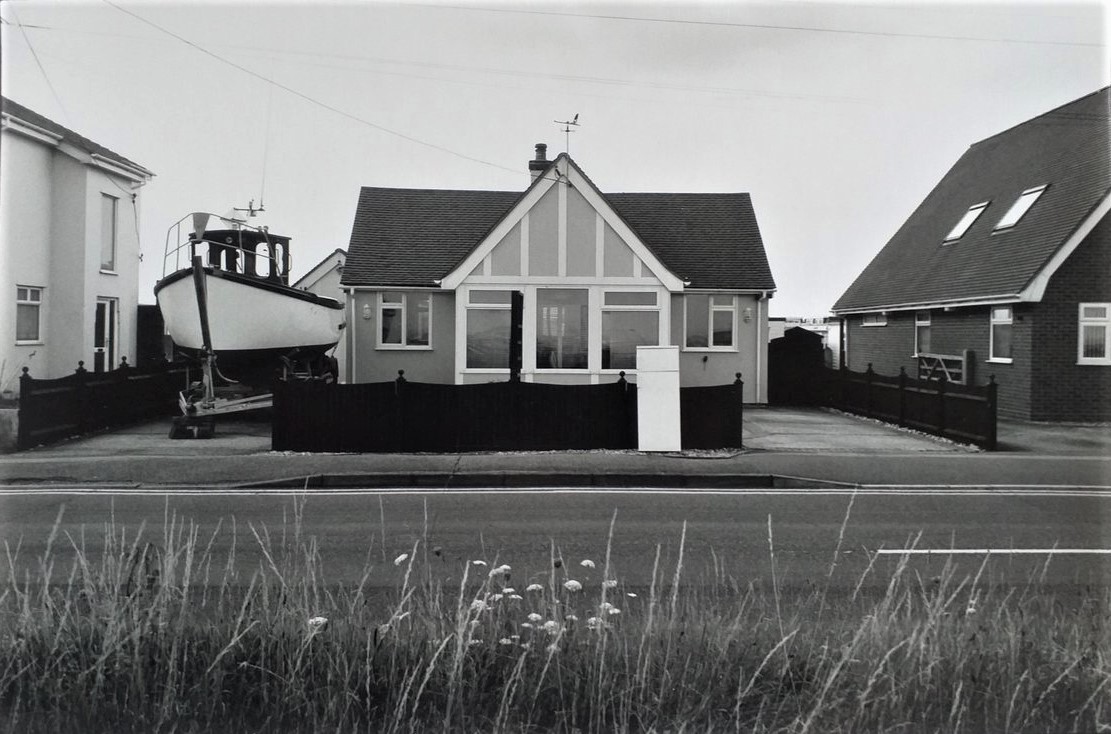 nicholas_sack's tweet image. Curious houses
Lade, Kent, 2014
Silver gelatin print
#Kent #Lade #Dungeness #RomneyMarsh #LyddonSea #streetphotography #bungalow #house #boat #motorboat #coast #seaside #rural #country #landscape  #road #street #sidewalk #pavement #gable #windows #grass #blackandwhite #film #bnw