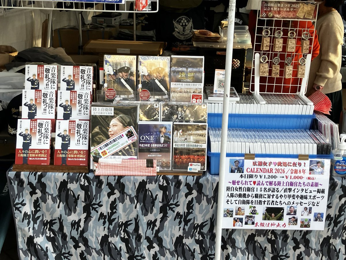 shosekika's tweet image. #自衛隊音楽まつり が今年も #日本武道館 にて開催されています。屋外の売店では、
自衛隊関連のグッズや本が販売されています。樋口孝博・元中央音楽隊隊長が執筆された『音楽隊に敬礼っ！』も並んでいますので、ご来場された方はぜひお手に取ってご覧ください！
＃自衛隊　＃防衛省　＃吹奏楽