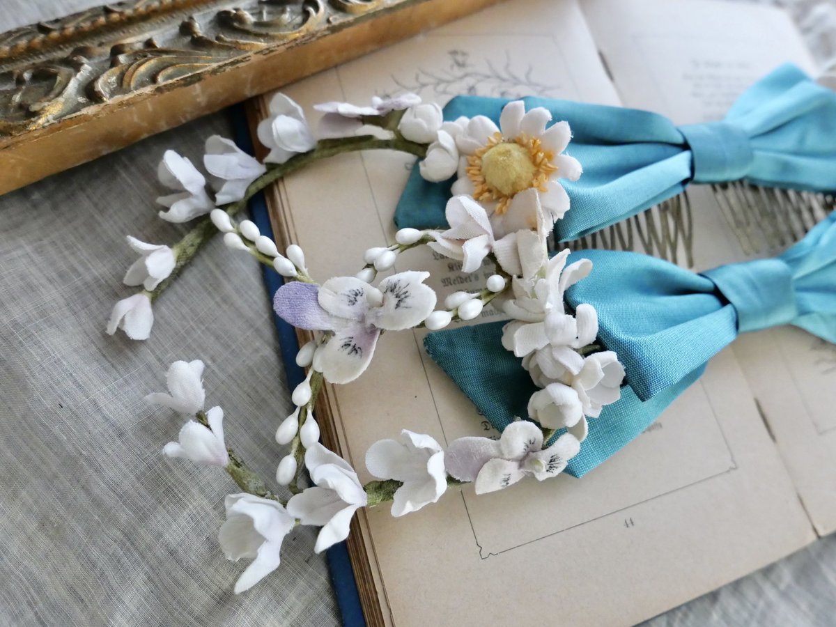 Wリボンブロッサムヘッドドレス

偏光色が入ったブルーのリボンが２つ並んだ、コームタイプのヘッドドレスです。

リボンの両サイドにはワイヤーに沿ってライラックやビオラ等が付いています。
頭や髪型によってワイヤーのカーブを変えてお使いください。

こちらもデザインフェスタにて販売致します。