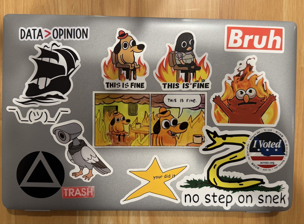 Only smart insiders will get that my work laptop stickers are an homage to American politics in 2025 inspired by <a href="/BulwarkOnline/">The Bulwark</a>. 🇺🇸 🏴‍☠️