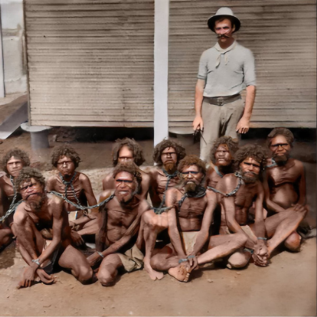 DaniMayakovski's tweet image. Un esclavista blanco británico posa con un grupo de negros nativos encadenados de pies y manos, entre ellos varios niños, en la prisión de Wydnham, que serían vendidos como esclavos hacia Occidente. (Australia, 1901)

Pocos conocen que hasta el año 1967, los nativos negros de…