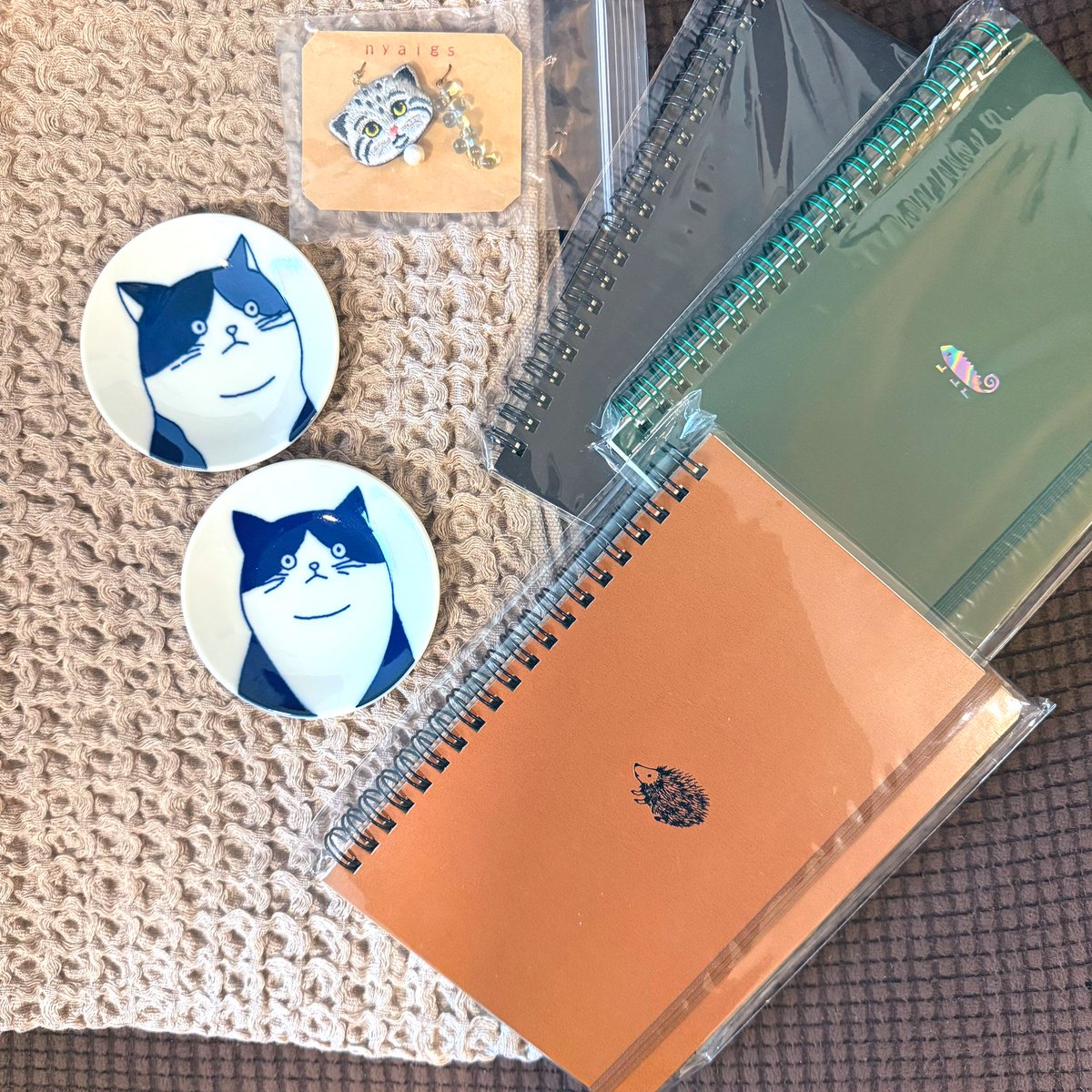 pipipi2828's tweet image. 今日はブラックフライデーなので世間はどんなもんなんだ…と思って街歩きをして偶然良いお店を見つけて入ったら店員さんに「店内10%オフだよっ！」と言われてたくさん買ってしまった…今治タオルブランケットと良い紙を使っているノート、可愛いCATの豆皿とマヌルネコのピアス…