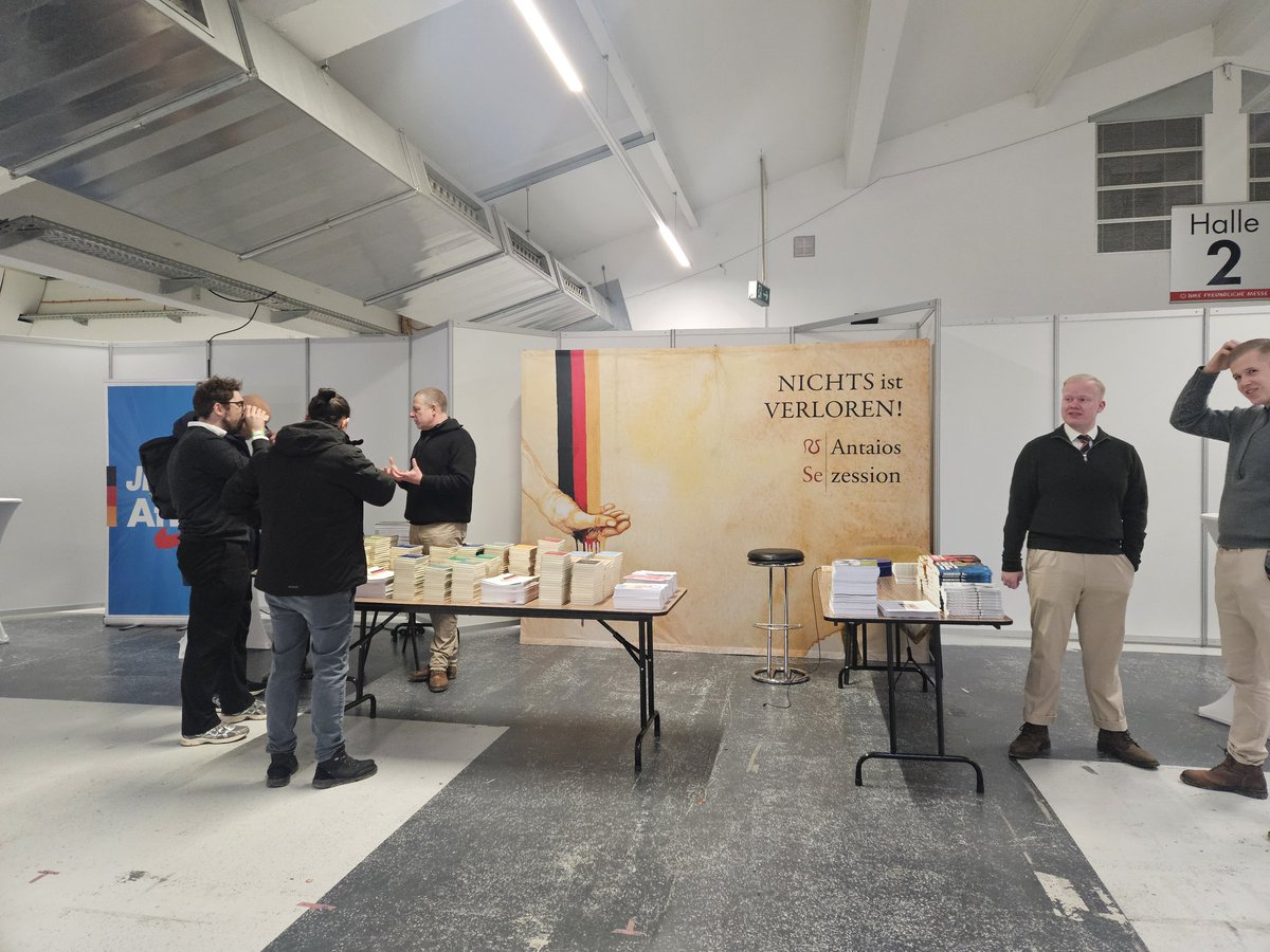Götz Kubitschek steht selbst am Antaois-Stand in der Halle beim Gründungskonvent der neuen AfD-Jugend in #Gießen. Ansonsten u.a. im Angebot: Remigrations-Sticker für 5 Euro von Wilhelm Kachel, Björn-Höcke-Fan-Shirts, Defender-Protein-Shake, Deutschlandkurier-Stand.