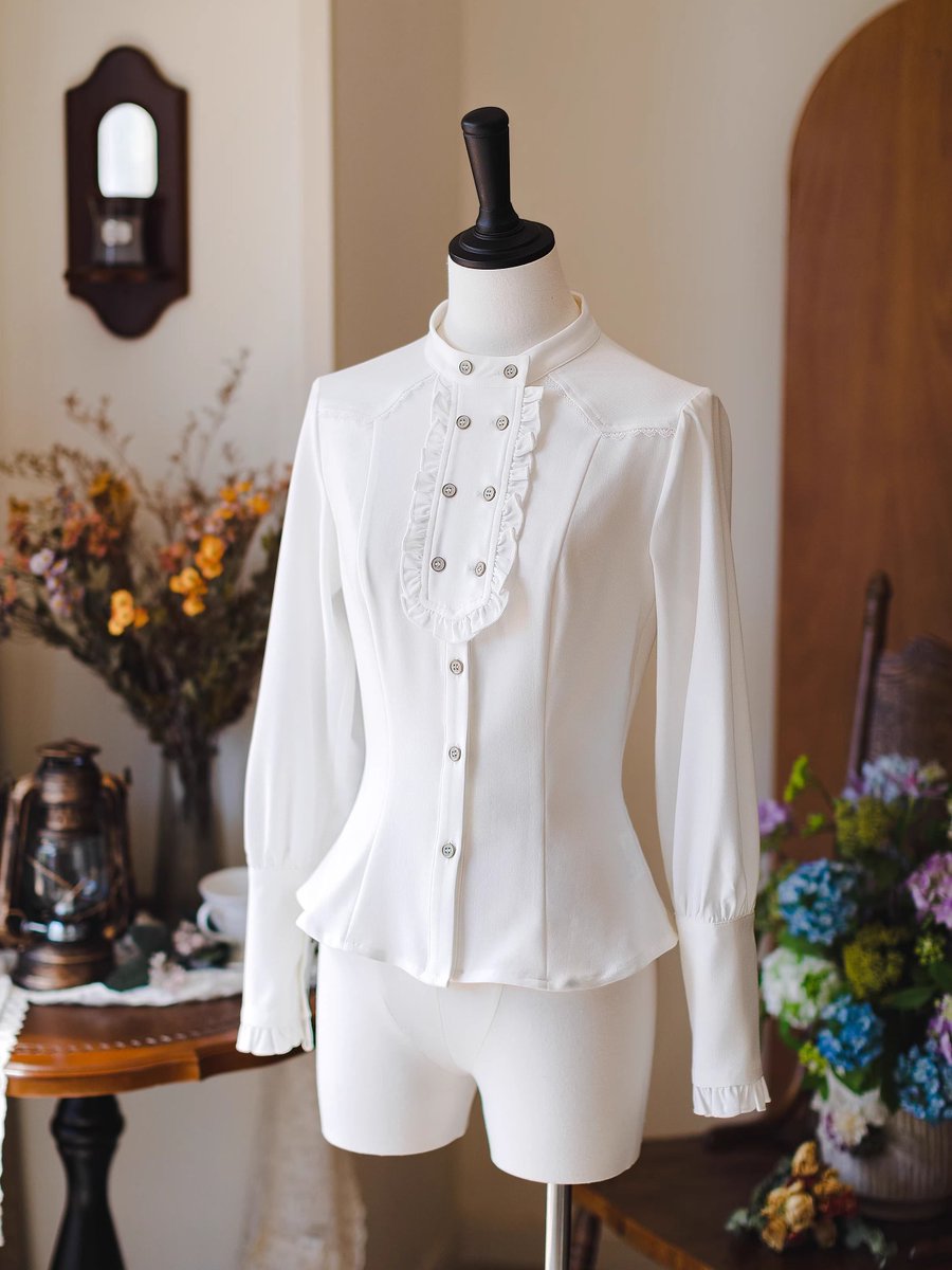 ManusxMachina's tweet image. 英国のお嬢様のスタンドカラーブラウス - White 
manus-machina.com/collections/ne… 
立ち上がった小ぶりのスタンドカラーから胸元へと続くダブルボタン仕様の前立てに、細かなフリルをあしらった端正でクラシカルなブラウス。前身頃は体の曲線を美しく見せるようにシェイプされ、上品さを際立たせています。