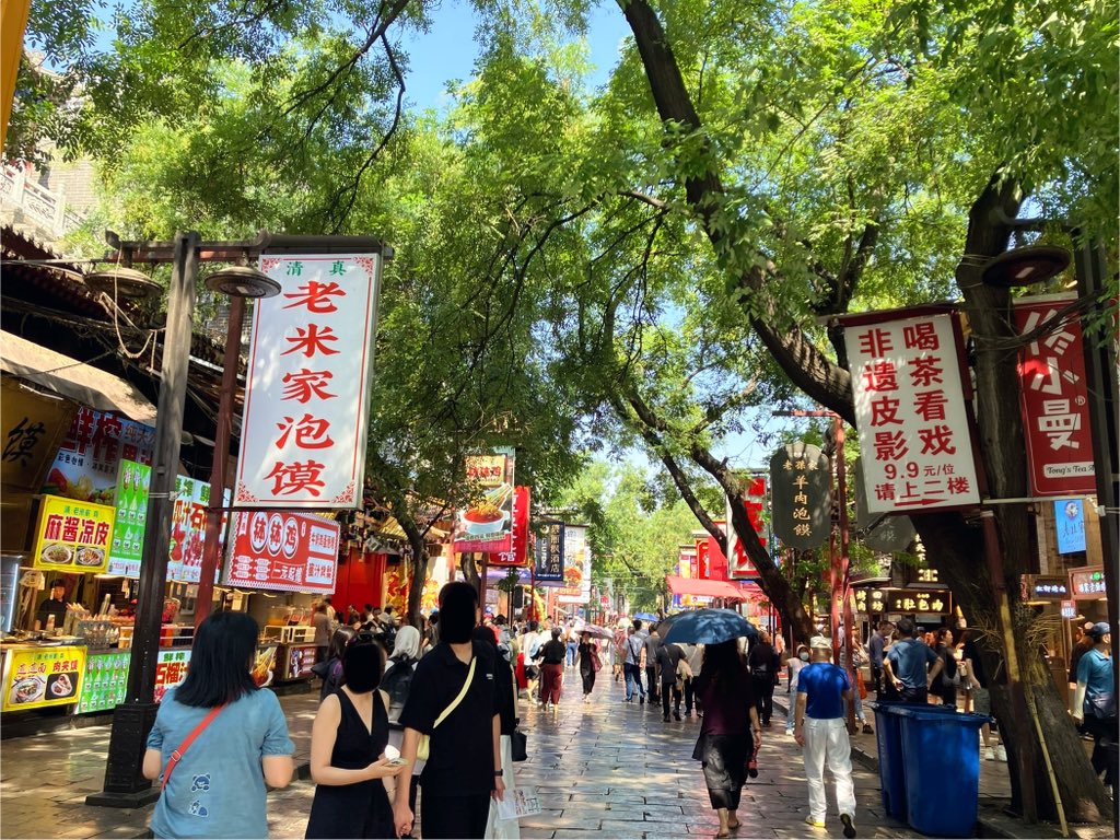 kado_travel's tweet image. 西安の歩行者天国・回民街にやってきた。両脇に飲食店や手工芸品店がズラリと立ち並ぶ。名前の通り回族(イスラム教)発祥のエリアで、豚肉を使わないハラル料理が中心。ここでは軽く食べ歩きをしてみた。飲み物は酸梅湯5元。おやつは黄桂柿子餅4元。柿と胡桃の味が濃厚、焼きたてで美味しかった