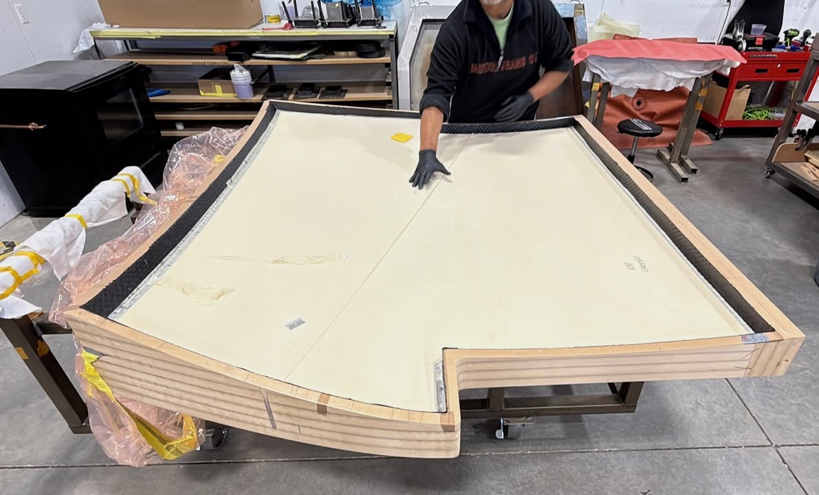 The Switchblade belly pan carbon fiber part is being laid up in the mold. Here's the middle layer of core material, tan colored, now in place over a layer of carbon fiber. This will be covered in carbon fiber outer layers, creating a strong sandwich panel. vist.ly/4f3kb