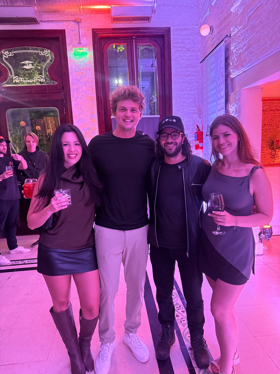 在布宜诺斯艾利斯 Alignment 活动上，彩色灯光下参会者们微笑合影