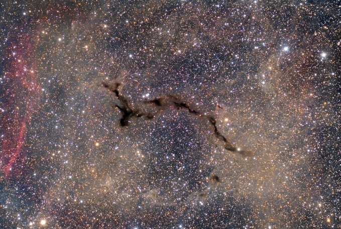 konstructivizm's tweet image. Barnard 150 Dark Nebula

This dark nebula in the constellation Cepheus, also known as the &quot;seahorse,&quot; is composed of dense clouds of interstellar dust that absorb the light from the stars behind it, creating the appearance of a dark spot against the bright galaxy.