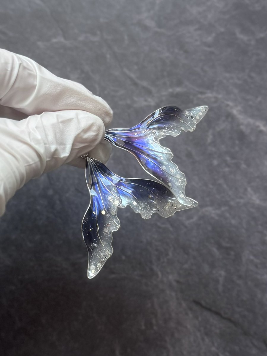 みなさま

耳飾り用の人魚のヒレを2種類、新しく作りましたので見てください❄️

ホワイトは 静寂に包まれた氷晶の景色
ネイビーは 冷たくも澄み切った冬の夜空をそれぞれイメージ。

星のようなラメの煌めきに加え、仕込まれた偏光カラーによる表情の変化に堪らなく心が刺激されること間違いなし…💘