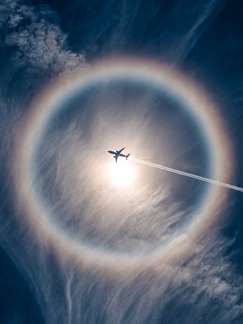 This plane hit the center of a solar halo with impossible precision

Captured over Nevada, USA