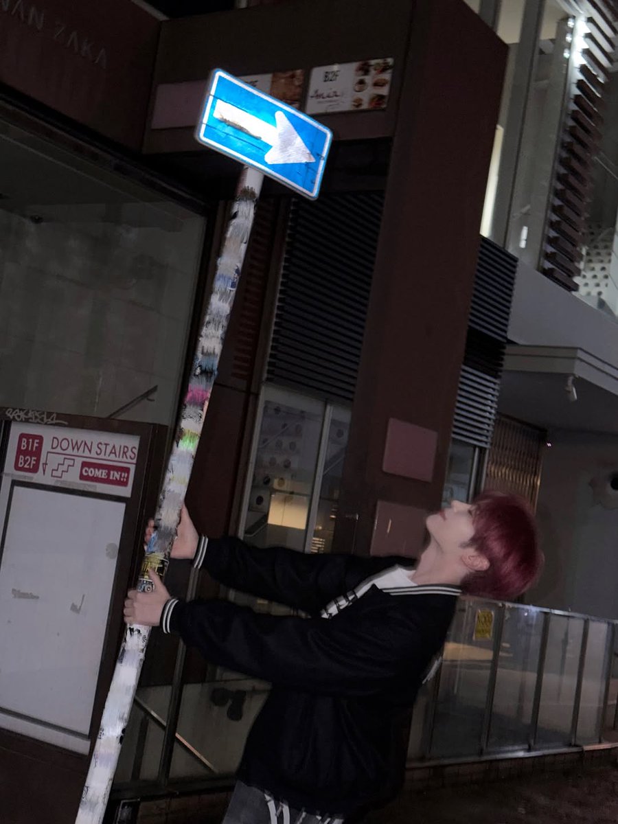 Hanbing's tweet image. Against this pole at night, pretending I’m in a music video. I’ve got my hands in my pockets, head tilted, and the street is my stage. If you catch me lost in thought under the city lights, know I’m probably humming my favorite song and plotting dance moves.