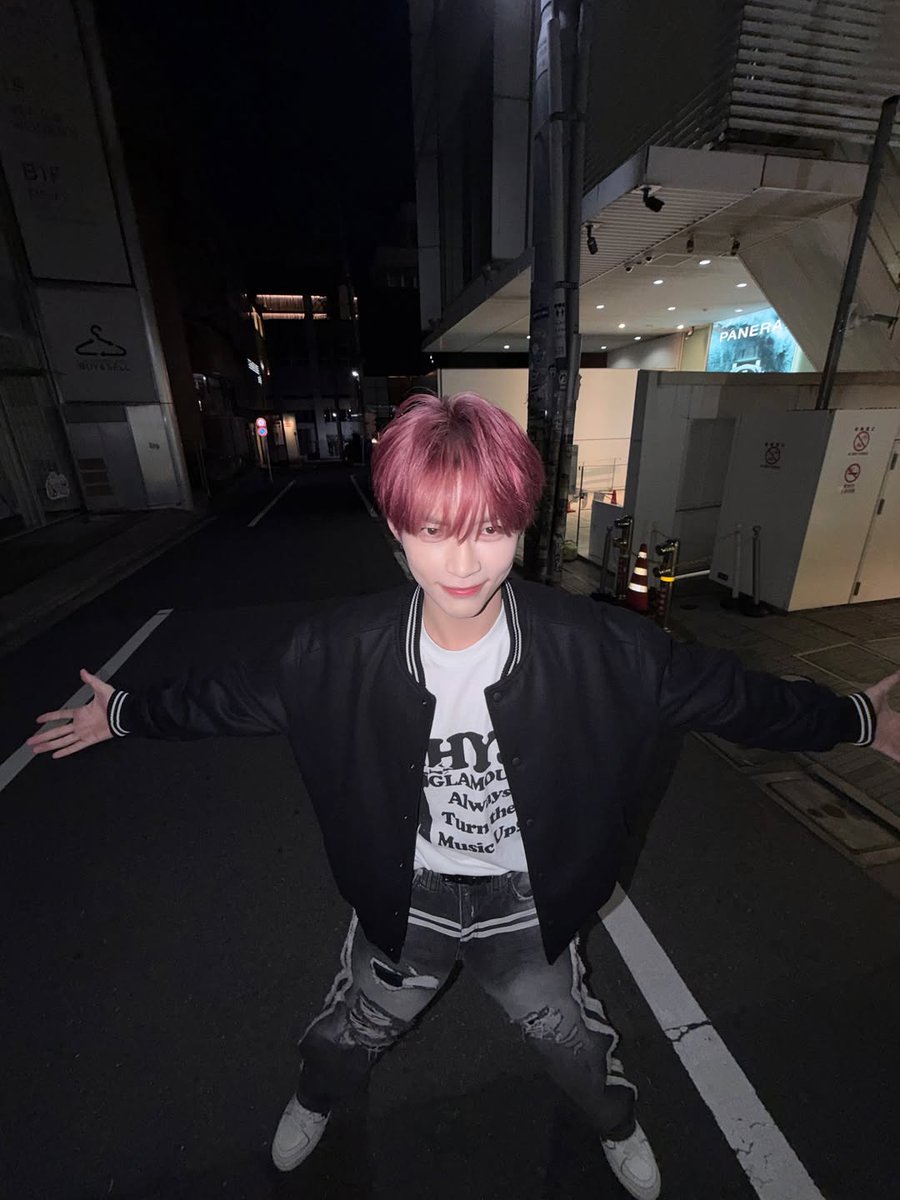 Hanbing's tweet image. Against this pole at night, pretending I’m in a music video. I’ve got my hands in my pockets, head tilted, and the street is my stage. If you catch me lost in thought under the city lights, know I’m probably humming my favorite song and plotting dance moves.
