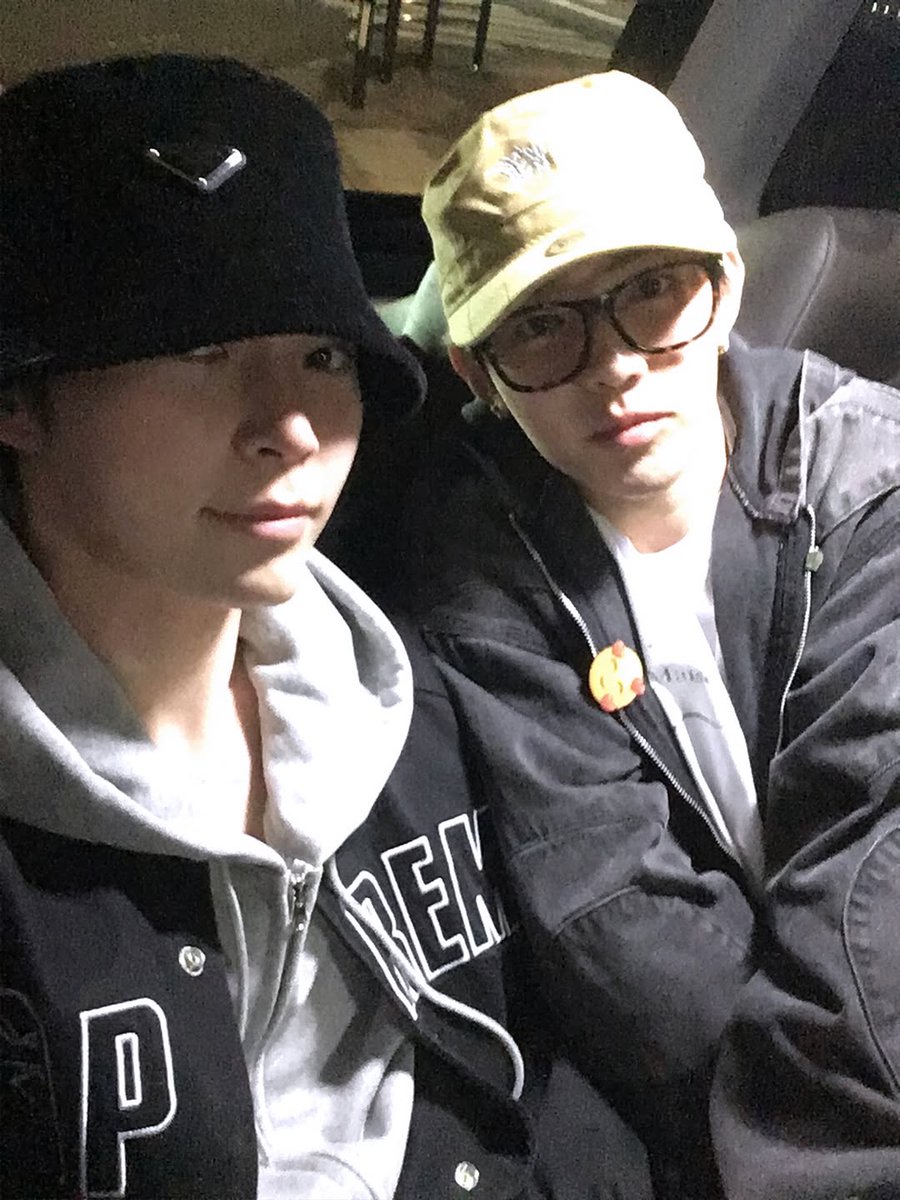 Hanbing's tweet image. Chillin’ in the car with my partner in crime. Two hats, two moods, one squad. We might look serious but trust me, we’re plotting our next snack stop. Late night rides always hit different when you’ve got good company, except for maybe more photos like this.