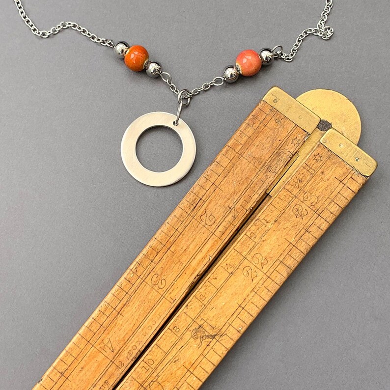 A bright and modern take on boho jewellery – this pendant necklace features an 'O'-shaped brushed pewter charm and vibrant orange ceramic beads for a playful pop of colour.

Purchase via Etsy: etsy.com/uk/listing/432…

#ceramicbeads #pewtercharm #beadednecklace